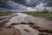 Crece el conflicto por la tasa vial: productores van a la Justicia por el destino de los fondos Camino rural colapsado tras lluvias extremas, con profundo socavón y agua desbordada bajo tormenta, reflejando la crisis vial que golpea al campo argentino