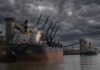 Récord histórico del agro: exportaciones en máximos, puertos saturados y un 2026 que puede marcar un antes y un después Buques de carga operando en el puerto del Gran Rosario sobre el río Paraná bajo un cielo de tormenta con nubarrones densos y oscuros, en un escenario de clima inestable