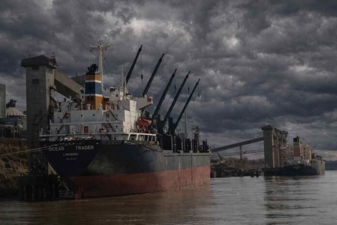 puerto-gran-rosario-buques-tormenta-nubarrones-rio-parana-ruralnet Buques de carga operando en el puerto del Gran Rosario sobre el río Paraná bajo un cielo de tormenta con nubarrones densos y oscuros, en un escenario de clima inestable
