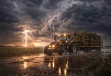 Se reconfigura el clima en el campo: tormentas fuertes en la zona núcleo y giro al sur del 20 al 22 de marzo Tractor agrícola transportando rollos de alfalfa bajo una tormenta extrema en la Pampa húmeda argentina, con lluvia intensa, relámpagos y campo anegado.