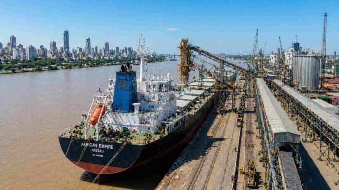 Buque granelero operando en terminal portuaria de Rosario con infraestructura de carga y silos en Argentina