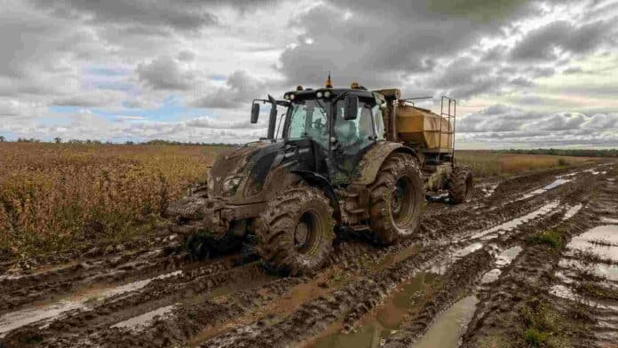 Maquinaria agrícola detenida en camino rural con barro por condiciones climáticas variables en la zona núcleo