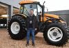 Abril en el campo: el mes donde se define el futuro productivo Ejecutivo del sector agro posando frente a un tractor agrícola de gran porte en una exposición de maquinaria en Argentina