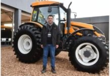 Abril en el campo: el mes donde se define el futuro productivo Ejecutivo del sector agro posando frente a un tractor agrícola de gran porte en una exposición de maquinaria en Argentina