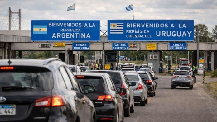 Paso fronterizo entre Argentina y Uruguay con vehículos en fila y controles aduaneros, clave para el comercio y el tránsito internacional.
