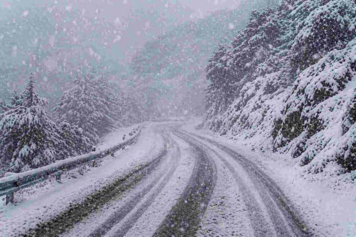 Ruta de montaña cubierta de nieve durante una nevada intensa en la cordillera de Neuquén, con baja visibilidad y acumulación en el camino