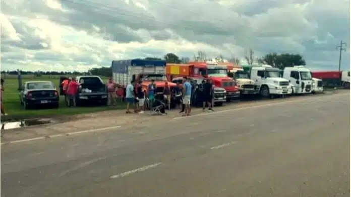 Camiones detenidos en ruta en Córdoba durante protesta, con cielo cálido de atardecer, reflejando el conflicto en el transporte de granos