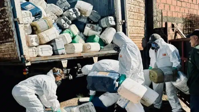 Operativo de retiro de bidones de fitosanitarios con personal protegido cargando envases en camión en Rosario del Tala, Entre Ríos