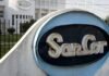 Se confirma el final de SanCor: la Justicia decreta la quiebra y busca vender sus plantas Cartel de SanCor en planta industrial con edificio de la cooperativa láctea al fondo en contexto de crisis