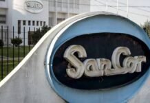 Se confirma el final de SanCor: la Justicia decreta la quiebra y busca vender sus plantas Cartel de SanCor en planta industrial con edificio de la cooperativa láctea al fondo en contexto de crisis