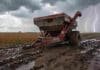 Dos alertas en simultáneo: lluvias de hasta 80 mm en el NEA y viento fuerte en la Patagonia Tolva agrícola encajada en el barro durante lluvia intensa en un lote de soja en la zona núcleo con tormenta y relámpagos