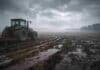 Los próximos tres días complican al agro: neblinas, inestabilidad y cambios de viento en zonas productivas Tractor agrícola trabajando en un campo embarrado con charcos y neblina bajo cielo nublado, reflejando condiciones de humedad, viento e inestabilidad en la Pampa húmeda argentina