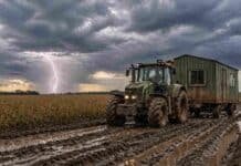 🔴 Tormentas en el norte y viento con ráfagas en la zona núcleo: así se mueve el clima este fin de semana Tractor tirando una casilla rural en camino con barro en un campo de soja bajo cielo nublado e inestable en la zona núcleo argentina