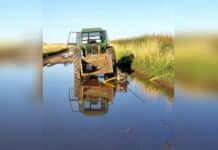 Se dispara el reclamo en el agro: tras inundaciones, productores exigen obras urgentes y denuncian abandono Tractor detenido en un camino rural completamente inundado, con agua cubriendo la traza y reflejando la crisis hídrica que afecta a zonas productivas de Buenos Aires.