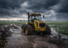 🌧️ Tres días con inestabilidad en el agro: neblinas, nubosidad y focos de tormenta afectan zonas productivas Tractor Pauny embarrado con conductor dentro de la cabina en un campo inundado bajo tormenta con lluvia intensa y relámpagos en la Pampa húmeda argentina