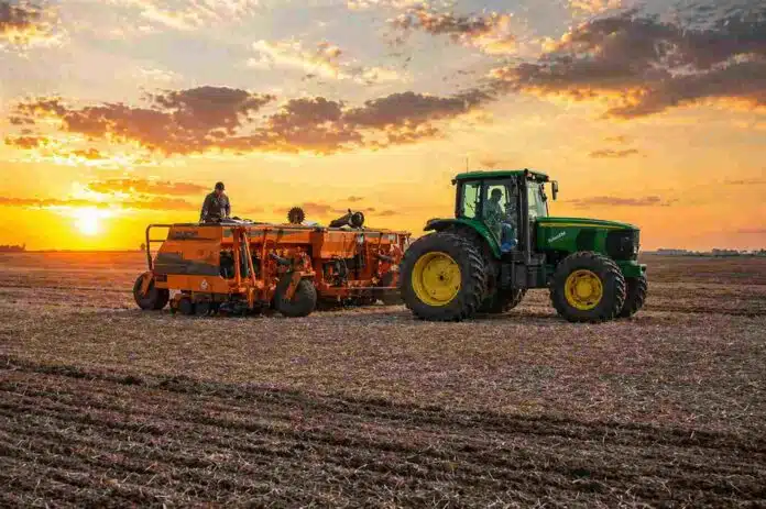 Tractor con sembradora trabajando en un lote seco al atardecer en la región agrícola de Córdoba Argentina