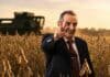 Moreno quiere subir retenciones si el peronismo vuelve al poder en 2027 Dirigente rural sonríe y hace la V en un lote de soja durante la cosecha, con una cosechadora trabajando al fondo al atardecer.