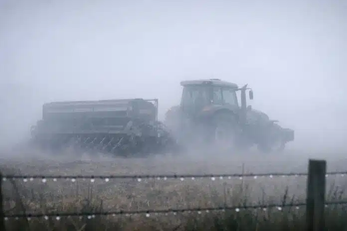 Tractor Valtra sembrando trigo entre niebla pampeana al amanecer, escena rural hiperrealista y cinematográfica.