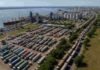 Récord histórico en el Gran Rosario ya descargaron 850.000 camiones con granos Vista aérea del puerto de Rosario con un playón lleno de camiones cerealeros y una extensa fila de vehículos esperando ingresar para descargar granos en terminales portuarias del Gran Rosario