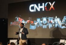 CNH presentó en el CX Day Argentina 2026 su modelo de experiencia del cliente para Case IH y New Holland en entornos B2B2C complejos Presentación de CNH con maquinaria agrícola proyectada en pantalla durante un evento del sector agroindustrial.
