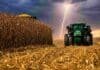 Santa Fe logra la mayor cosecha de maíz de los últimos 6 años y exportará más de 500.000 toneladas Tractor trabajando en un lote de maíz bajo un cielo de tormenta con relámpagos durante la cosecha en un campo argentino