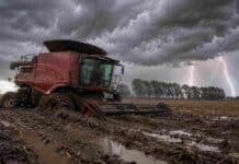 Pronóstico de lluvias hasta el 25 de mayo Cosechadora encajada en el barro durante una fuerte tormenta eléctrica en un campo argentino con lluvia intensa, relámpagos y suelo completamente anegado