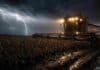 Se viene la humedad que el campo estaba esperando: el pronóstico para los próximos tres días Cosechadora trabajando en un campo de soja embarrado bajo una tormenta intensa, con luces encendidas, relámpagos al fondo, lluvia fuerte y barro reflejando la luz en una escena rural dramática.