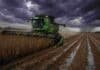 La cosecha de soja toma ritmo tras las mejoras climáticas Cosechadora trabajando en lote de soja con cielo de tormenta y suelo mojado en campo argentino, bajo condiciones climáticas adversas