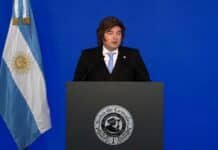Milei anunció la baja de retenciones para el trigo, la cebada y la soja, y extendió los recortes a la industria Dirigente político argentino durante un discurso en la Bolsa de Cereales, con bandera nacional y fondo azul en un acto institucional.
