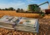Dos proyectos en Diputados buscan eliminar las retenciones al agro en tres y cuatro años y quitarle al Ejecutivo la facultad de modificarlas por decreto Billetes de dólar sobre una mesa rural con una cosechadora trabajando en un lote de trigo durante la campaña agrícola argentina.