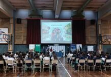 BASF lleva el agro a las aulas: el 90% de los secundarios no sabe de dónde vienen los alimentos que come Charla educativa sobre agro con estudiantes en auditorio escolar, con presentación en pantalla y público sentado escuchando en Argentina.