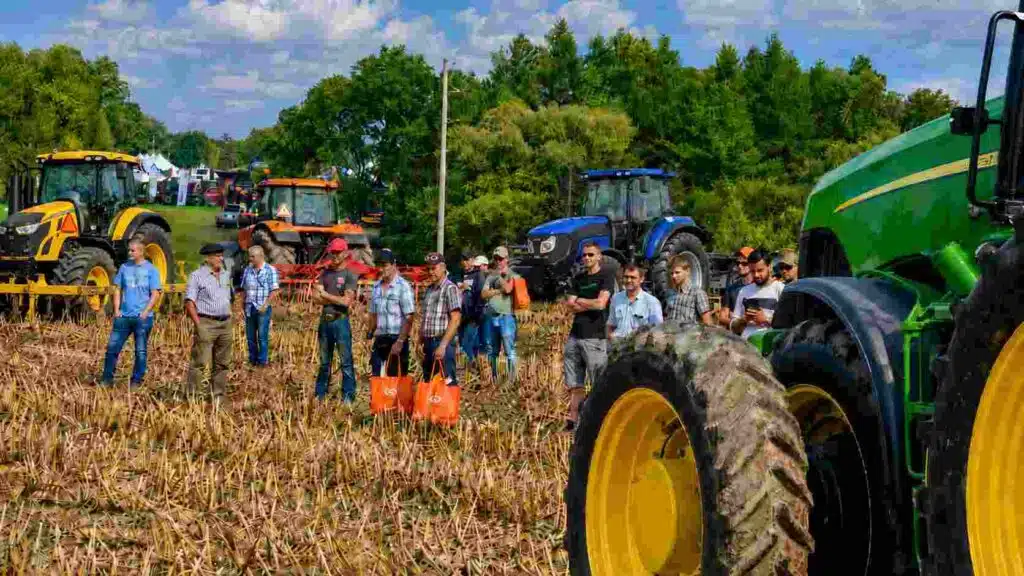Zona Dinámica de la Expo Rural 2026 con tractores y maquinaria agrícola trabajando a campo, mientras productores y visitantes observan la demostración en un lote con rastrojo.
