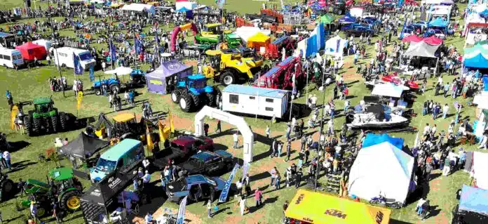 expo-rural-vista-aerea-maquinaria-publico-stands Vista aérea de la exposición rural del Litoral con maquinaria agrícola, tractores, stands comerciales y gran concurrencia de público recorriendo el predio al aire libre.