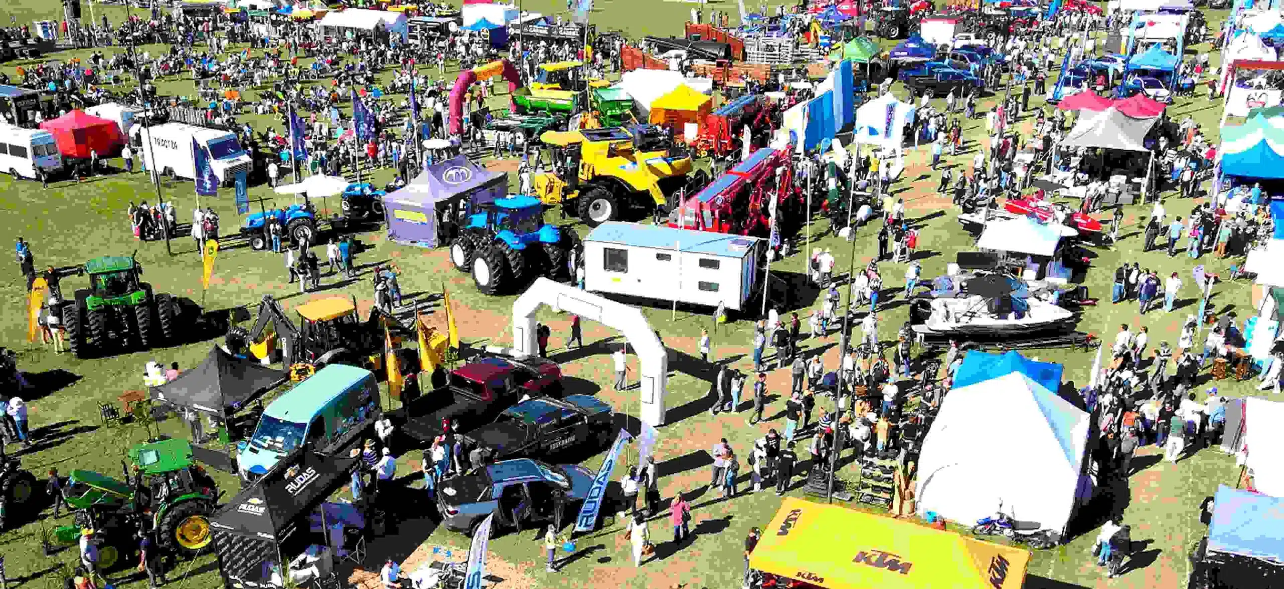 Vista aérea de la exposición rural del Litoral con maquinaria agrícola, tractores, stands comerciales y gran concurrencia de público recorriendo el predio al aire libre.