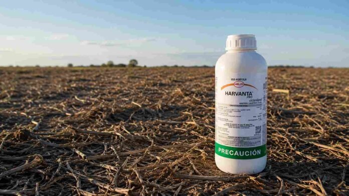 Envase de insecticida Harvanta Pro de HELM sobre un lote en barbecho con rastrojo seco y horizonte rural en la región agrícola argentina.