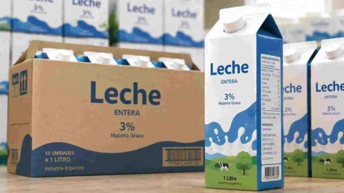 leche-entera-industria-lactea-ruralnet Envases de leche entera sin marca exhibidos junto a cajas de distribución, imagen ilustrativa sobre industria láctea y comercialización de productos lácteos.