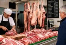 Carne: del campo al mostrador, el precio arranca en $9.774 el kilo en gancho y choca contra un consumo en 43 kg Media res colgada y cortes de carne exhibidos en carnicería argentina, mostrando la cadena de valor desde la faena hasta el mostrador.