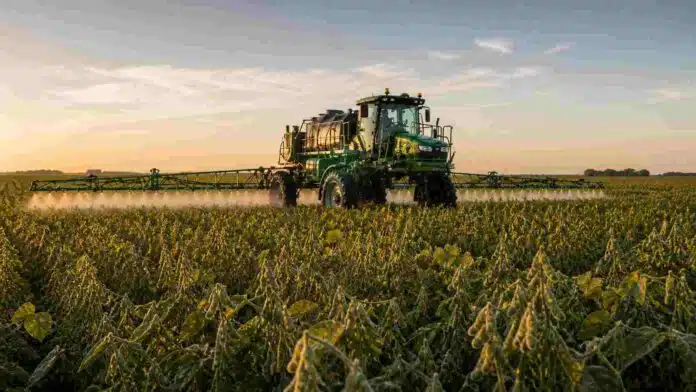 pulverizadora-soja-r7-aplicacion-fitosanitarios-pampa-humeda-ruralnet Pulverizadora autopropulsada aplicando fitosanitarios sobre un cultivo de soja en estadio R7 en la pampa húmeda argentina, con luz de atardecer y condiciones de campo productivo.