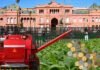 Milei anunció la baja de retenciones. El campo lo recibió con optimismo pero pide llegar a cero Cosechadora roja junto a un cultivo de soja y monedas frente a la Casa Rosada, en una imagen conceptual sobre retenciones al agro.