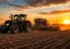 La siembra de trigo 2026/27 avanza a ritmo récord gracias a la buena humedad Tractor Valtra sembrando trigo con una sembradora de granos finos en un campo en barbecho al atardecer, con polvo suave y cielo dorado.