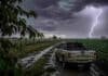 Lluvias de abril en Córdoba superaron el promedio histórico y mejoraron la humedad para la campaña de invierno Tormenta con lluvias intensas en camino rural, pickup Mitsubishi L200 embarrada bajo relámpagos y cielo oscuro con cortinas de lluvia