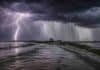 ⚠️ Hasta 90 mm y tormentas fuertes: 7 provincias bajo alerta por lluvias intensas Tormenta severa con lluvias intensas en zona rural argentina, camino inundado con pickup a lo lejos y relámpago ramificado bajo nubes oscuras y cortinas de lluvia