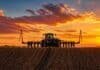 Arrendamientos en Córdoba 2026/27: bajan a 11,5 qq/ha pero sube el costo en dólares del alquiler agrícola Tractor sembrando en campo argentino al atardecer con cielo naranja intenso y surcos de tierra en primer plano