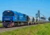 El Gobierno eximió de impuestos aduaneros a los trenes de carga para evitar un encarecimiento del 40% en las inversiones Formación del tren Belgrano Cargas con vagones cerealeros transportando granos en zona rural argentina, con silos y campos agrícolas de fondo.
