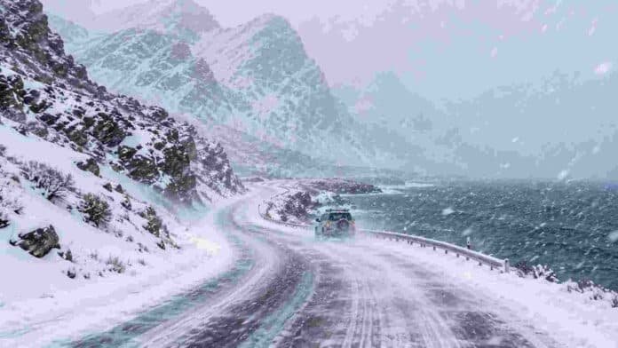 Intensa nevada sobre una ruta cordillerana de la Patagonia argentina, con fuertes ráfagas de viento, baja visibilidad y montañas cubiertas de nieve junto a la costa.
