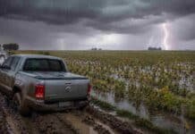 Hasta 60 mm de lluvias persistentes: el alerta del SMN cubre zonas de seis provincias Pick up Amarok encajada en un camino rural embarrado junto a un lote de soja en estado R7 parcialmente anegado, bajo una tormenta intensa con lluvia y relámpagos en la Pampa Húmeda argentina