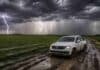 Pronostican lluvias persistentes en regiones clave del agro y tormentas fuertes en el norte Camioneta blanca encajada en un camino rural embarrado durante una tormenta severa, con lluvias intensas, relámpagos y un campo agrícola bajo un cielo oscuro y amenazante.