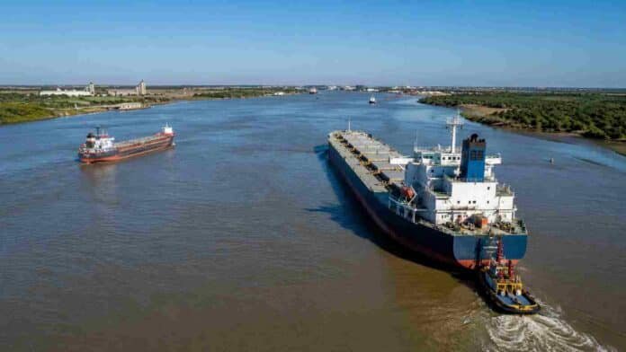Buques de carga navegando por la Hidrovía, con remolcador y actividad portuaria en una vía fluvial estratégica para el agro.