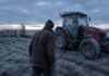 Alerta amarilla por frío extremo en 13 provincias: el SMN advierte sobre riesgos para la salud de grupos vulnerables Productor agropecuario abrigado caminando hacia un tractor Massey Ferguson cubierto de escarcha en un campo argentino con helada intensa, cielo gris y luz fría de amanecer