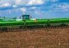 Campaña fina 2026: el trigo ya cubre el 55% del área prevista y muestra una germinación de buena a excelente Sembradora de granos finos trabajando en un campo agrícola con rastrojo, bajo un cielo despejado con nubes, durante una jornada de siembra de trigo.